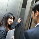 エレベーターのボタンを押す女性